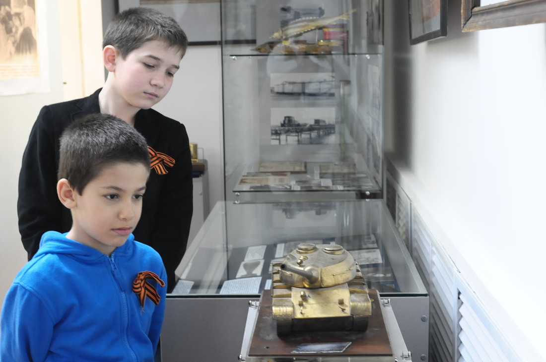 Школьники с интересом рассматривают макет танка времен Великой Отечественной войны