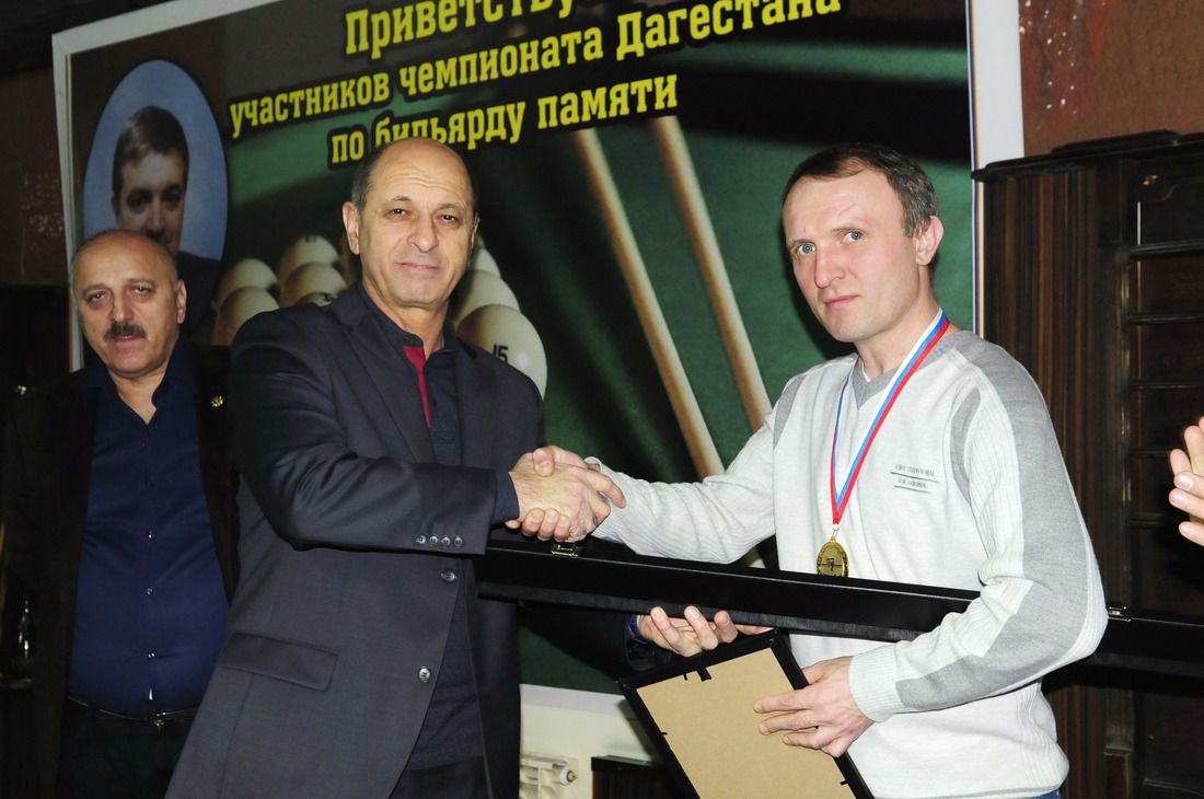 Победителя турнира по бильярду Магомеда Ахмедова награждает главный инженер Общества Мурад Абакаров